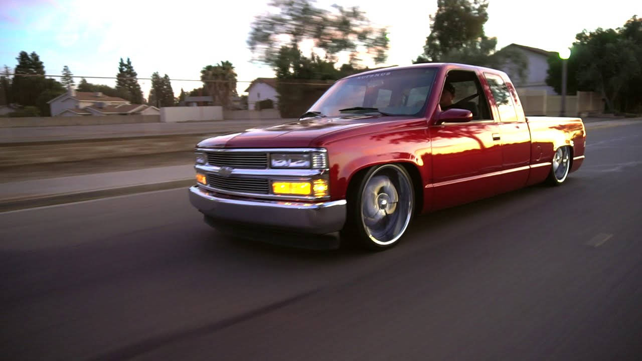 Stunning Red Dropped Truck On Open Road. Wallpaper