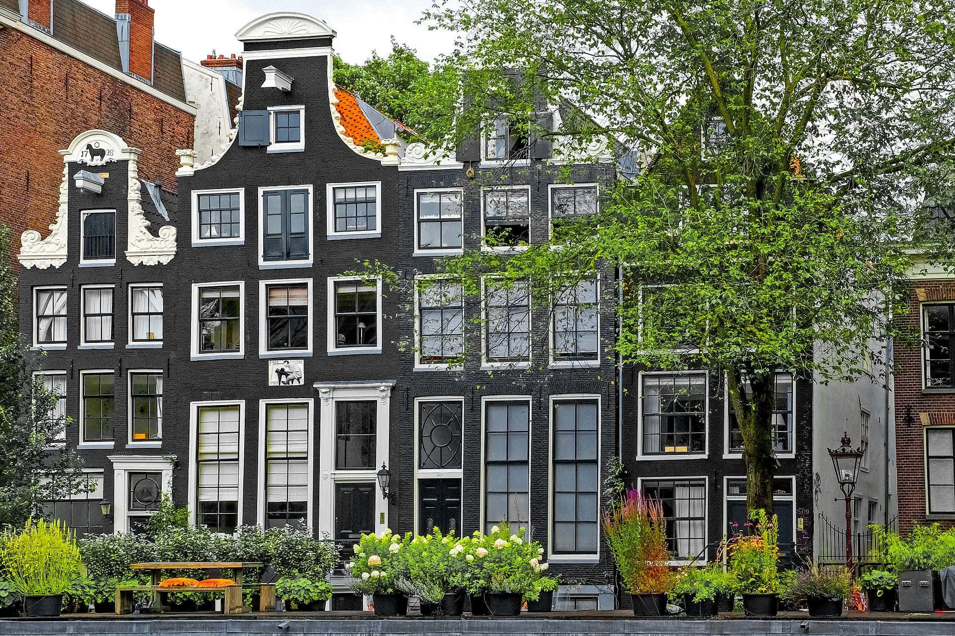 Take A Stroll Along The Canals Of Amsterdam In The Springtime Wallpaper