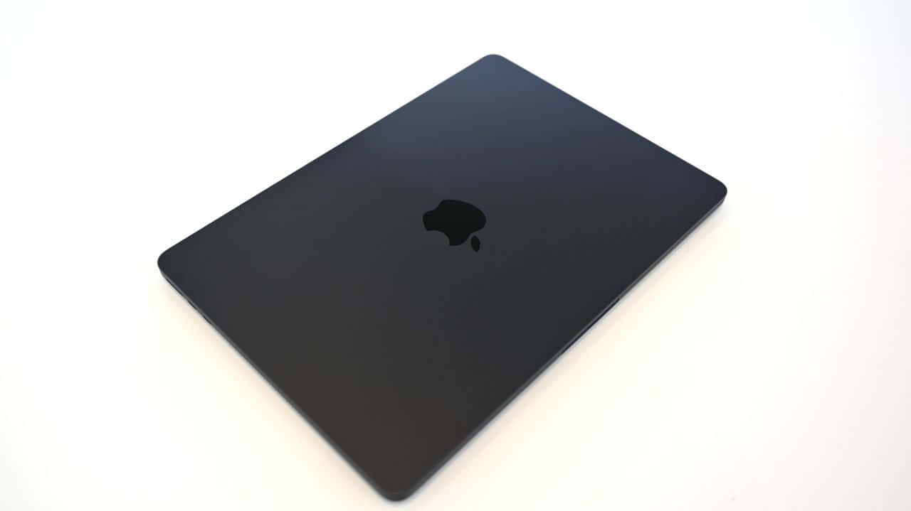 Take Your Work With You In Style With A Black Macbook Wallpaper