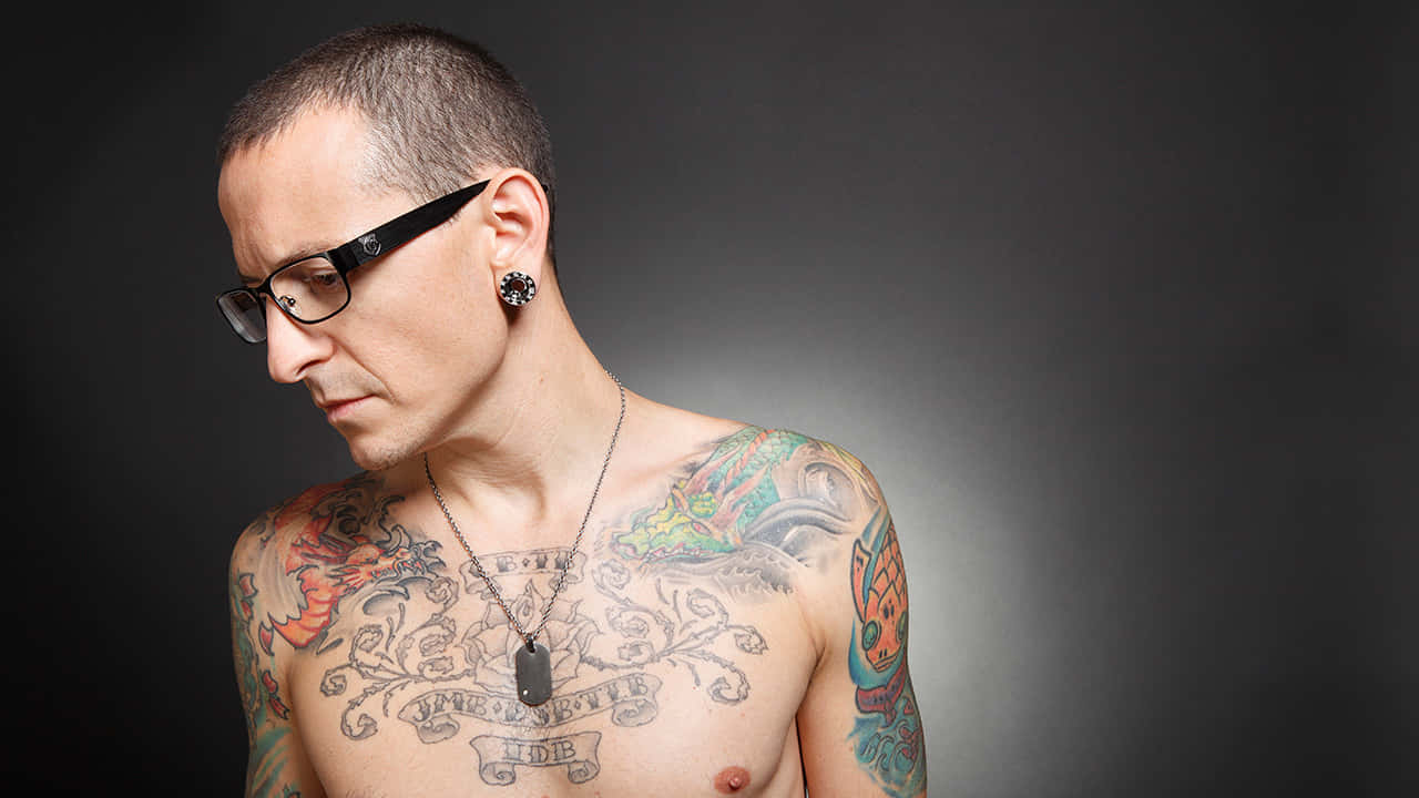 Tattooed Manwith Glasses Wallpaper