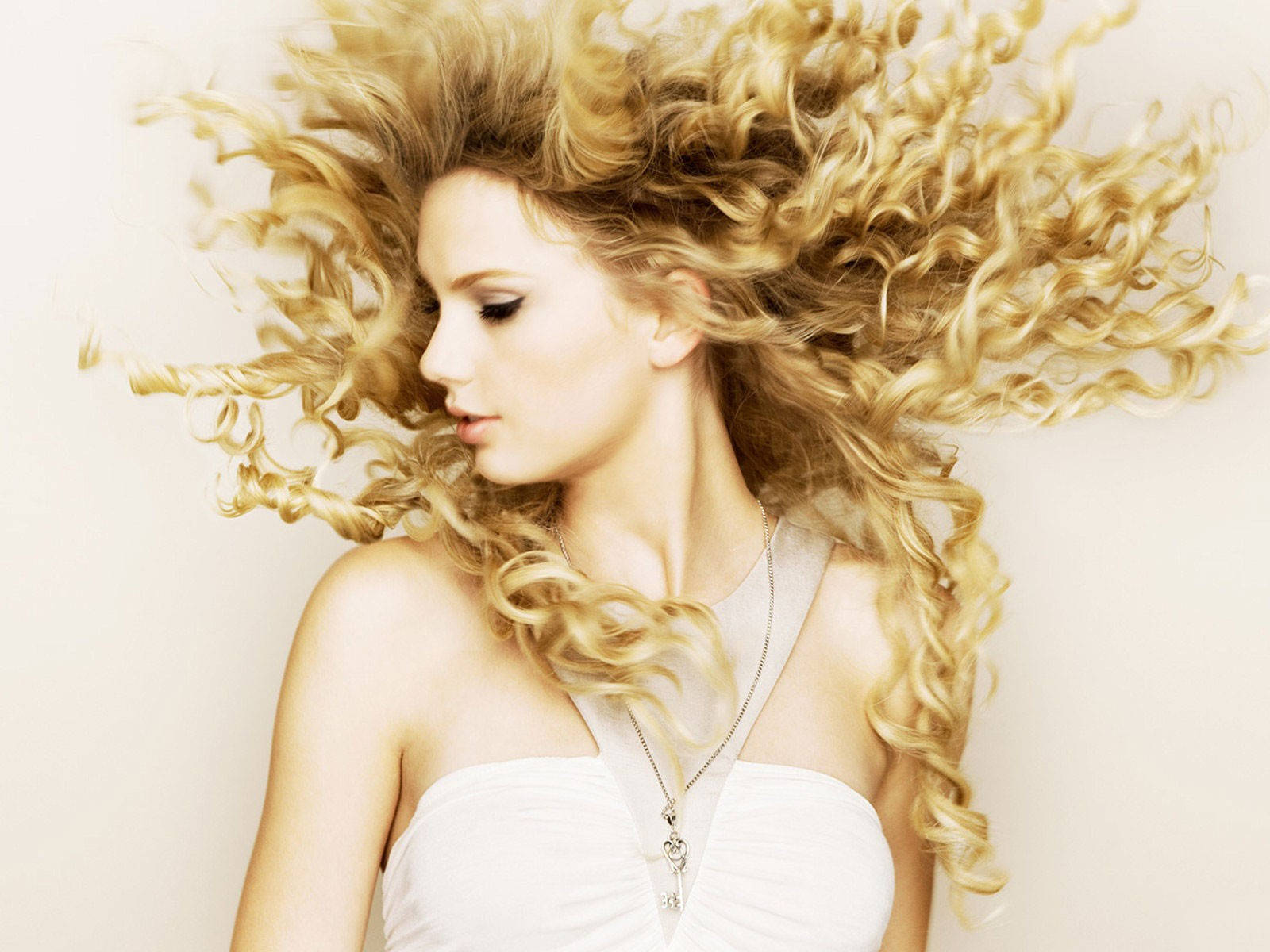 Taylor Swift With A Heavy Curl Hairstyle Wallpaper