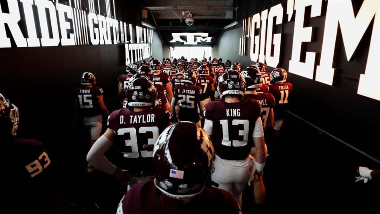 Texas Am Football Players Walk Down A Hallway Wallpaper