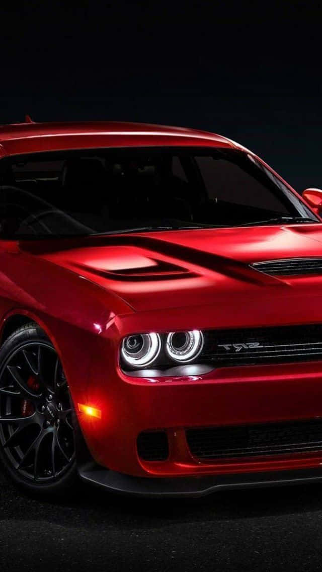 The Red Dodge Challenger Srt Is Shown In A Dark Room Wallpaper