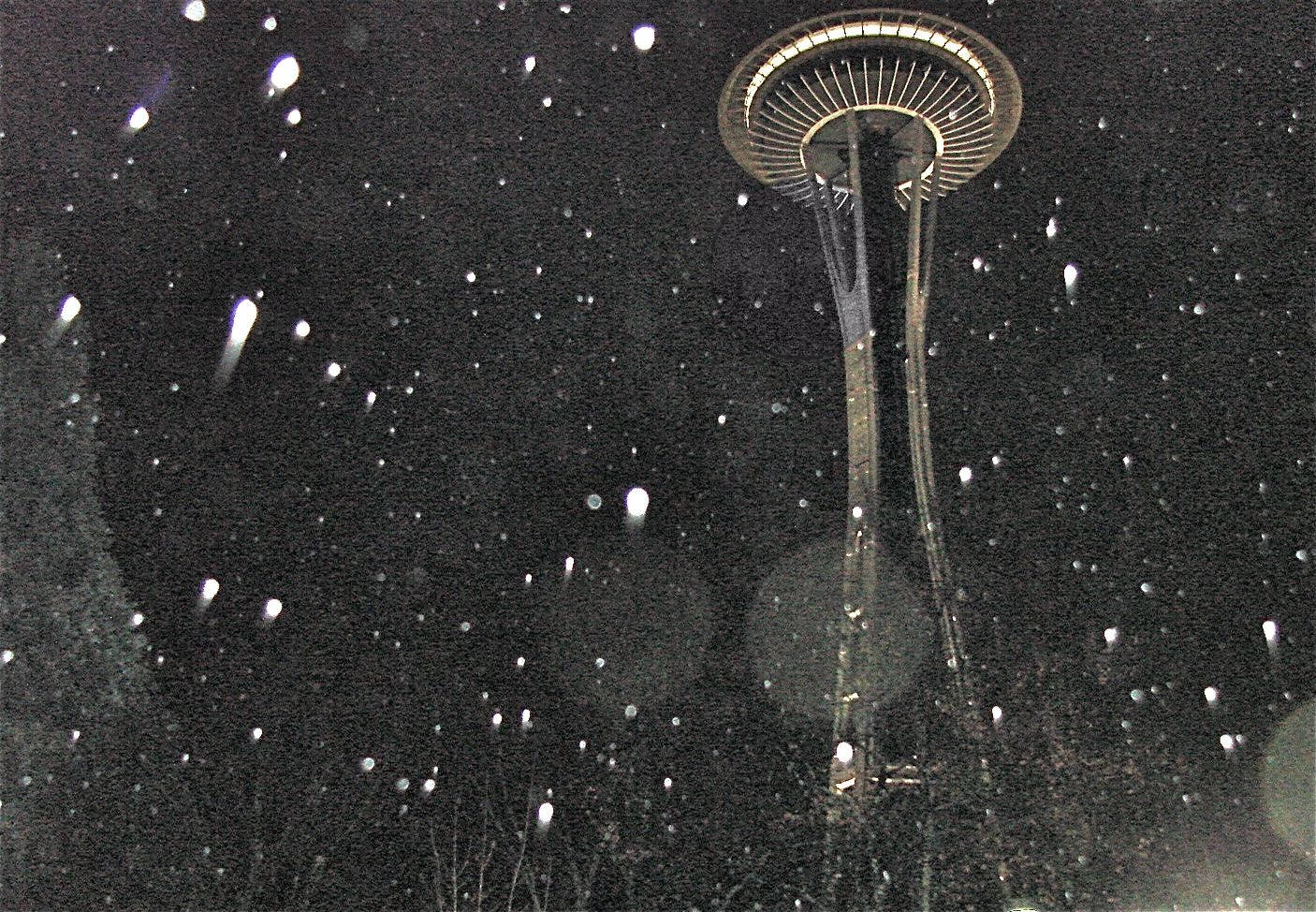 The Space Needle Piercing Through Seattle's Misty Rain Under Moody Dark Skies. Wallpaper