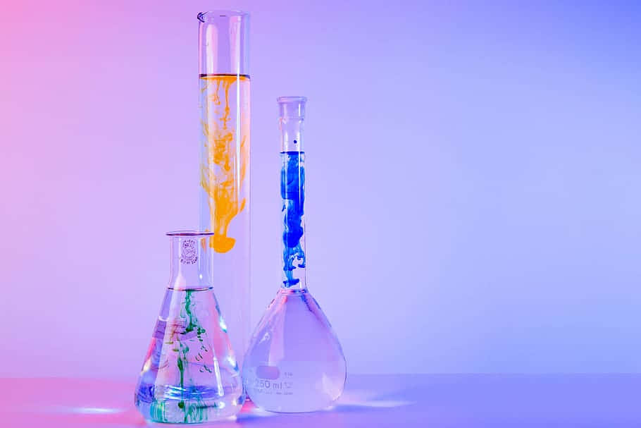 Three Glass Flasks With Different Colors Of Liquid Wallpaper