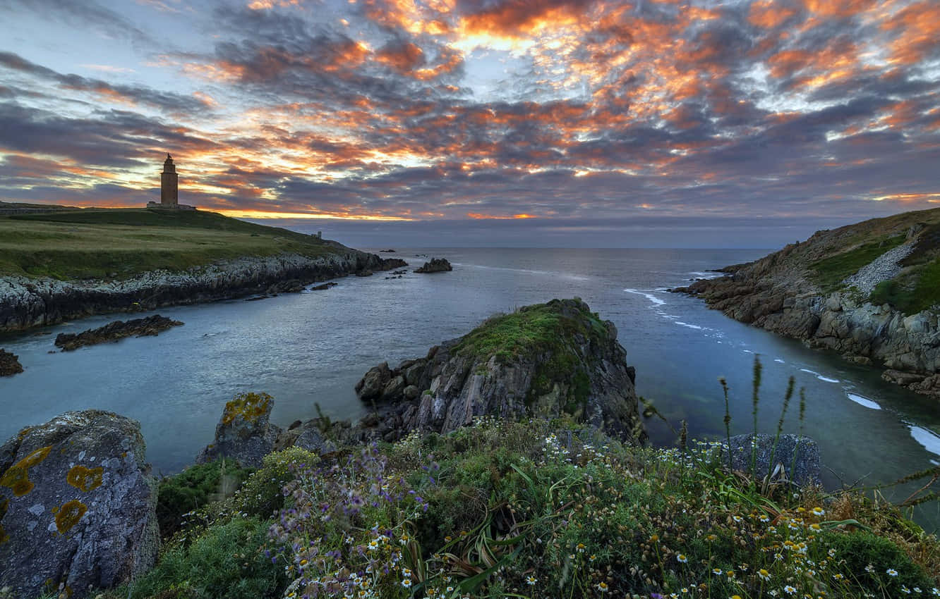 Tower Of Hercules Beneath The Cloudy Sunset Sky Wallpaper