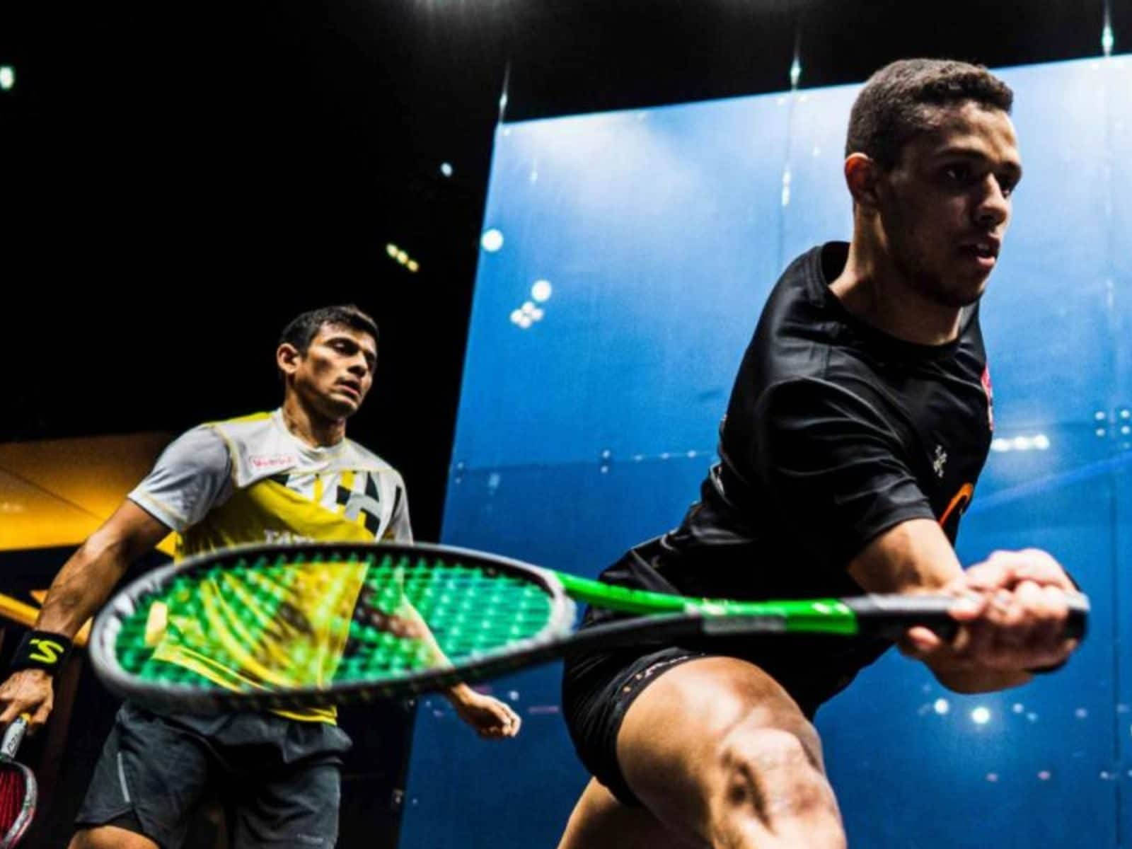 Two Athletic Boys Engaged In A Friendly Game Of Squash Wallpaper