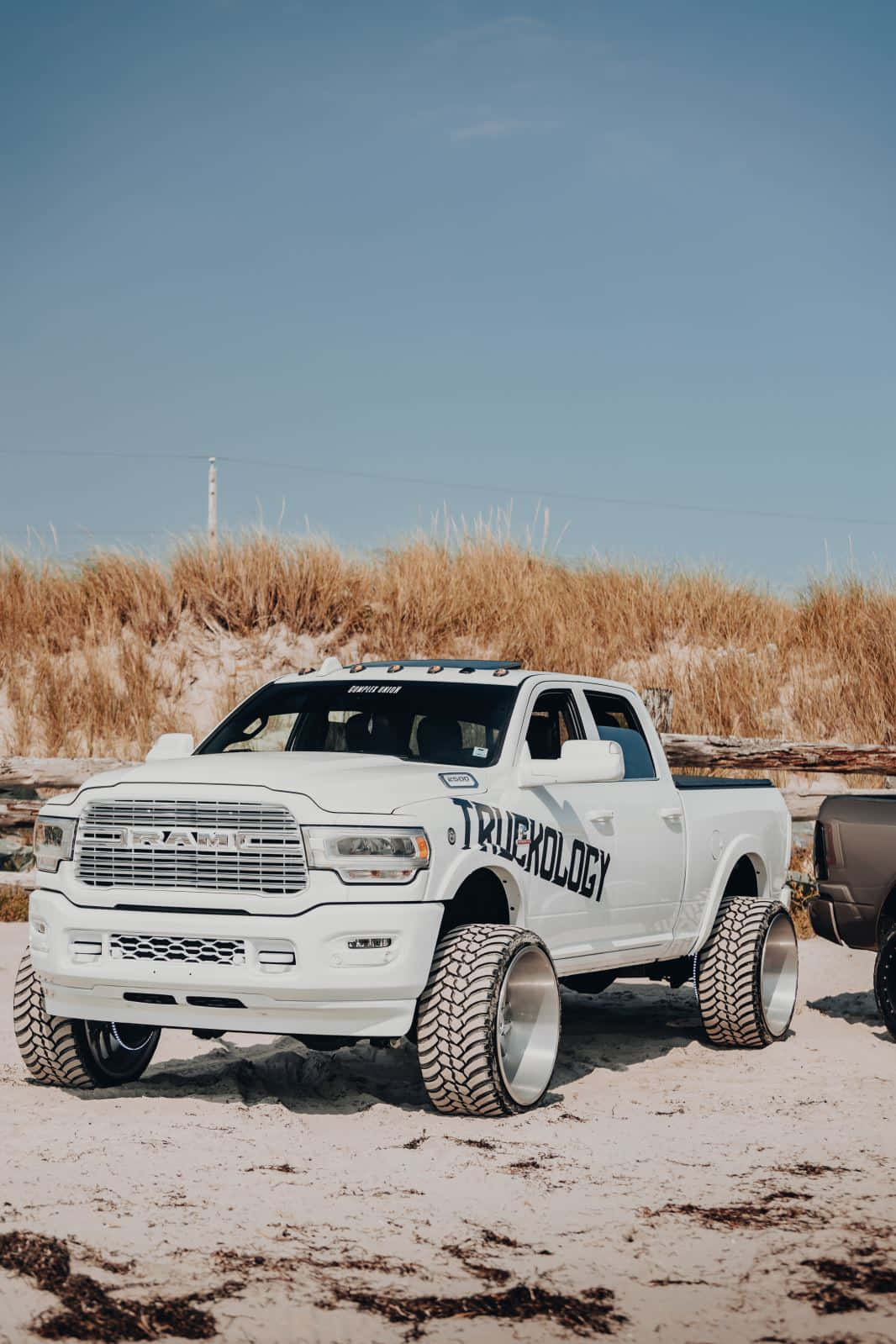 Two White Trucks Parked On The Beach Wallpaper