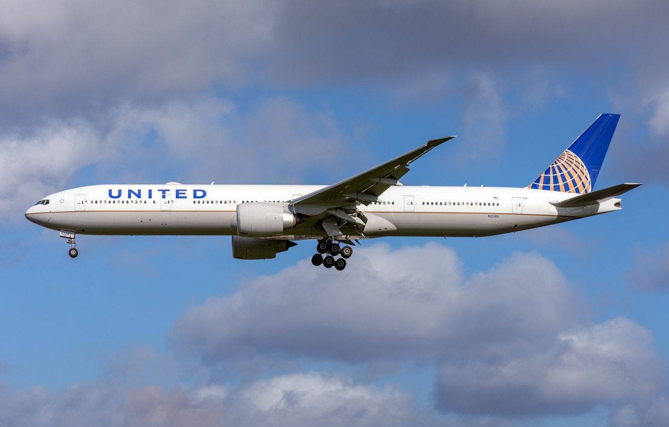 United Airplane Soaring Against Cloudy Sky Wallpaper