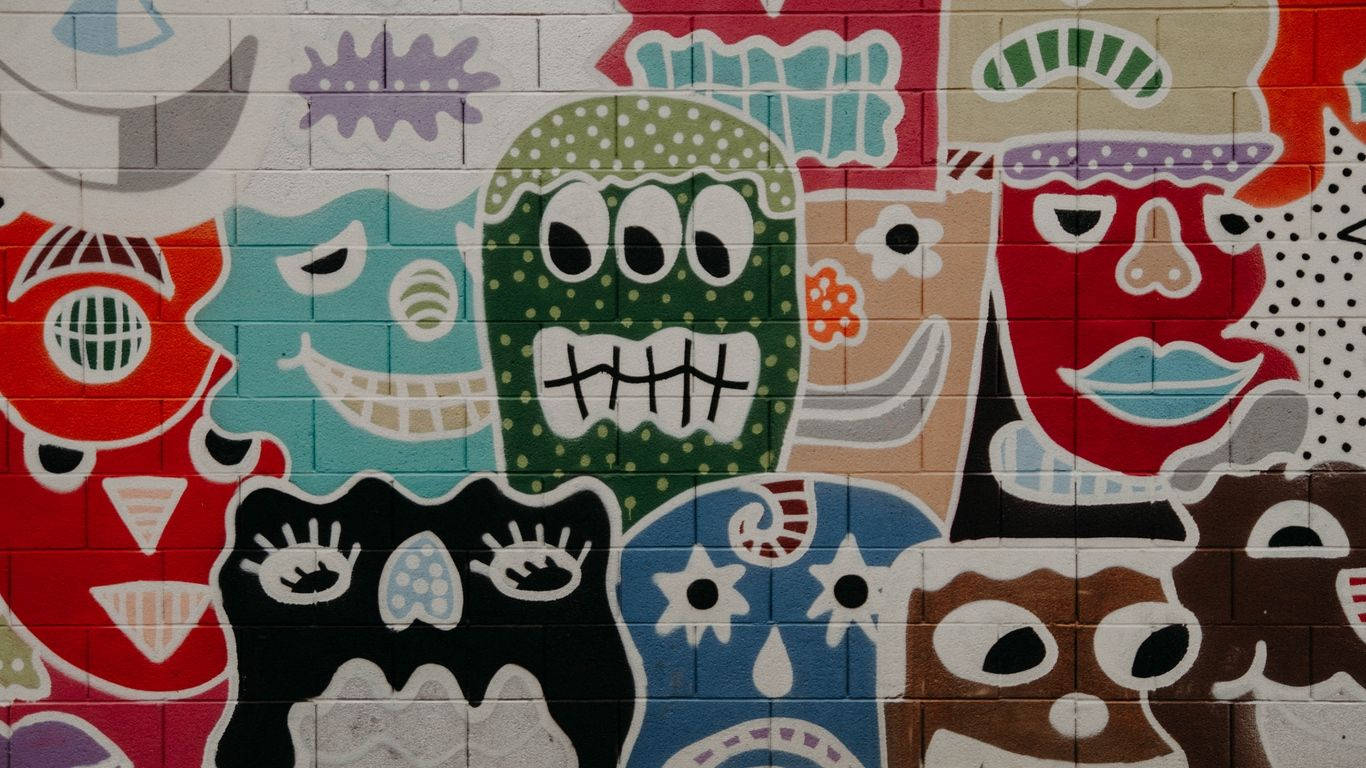 Unleashing Creativity With Colorful Graffiti Monster Faces On A Laptop Wallpaper