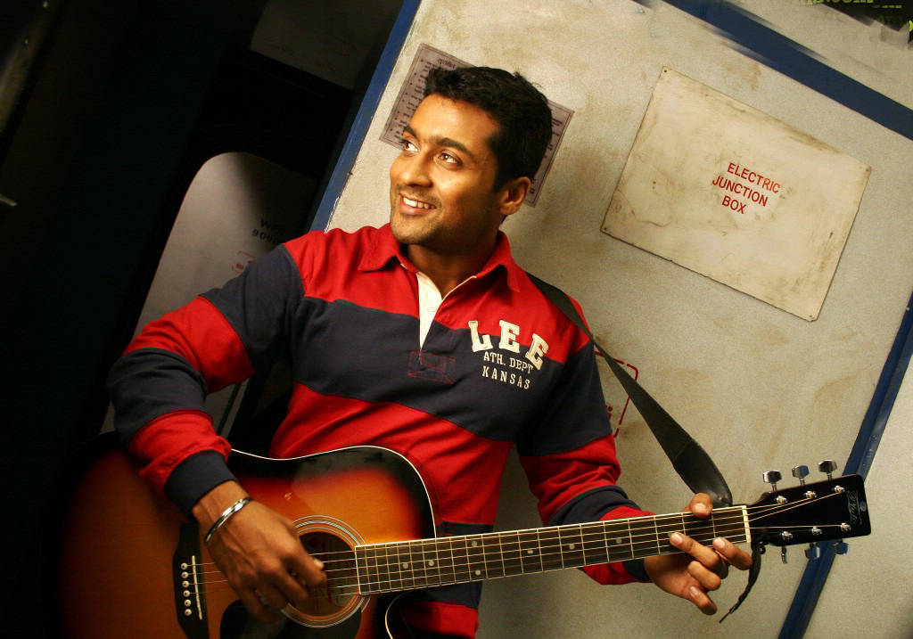 Vaaranam Aayiram Surya Smiling While Playing A Guitar Wallpaper