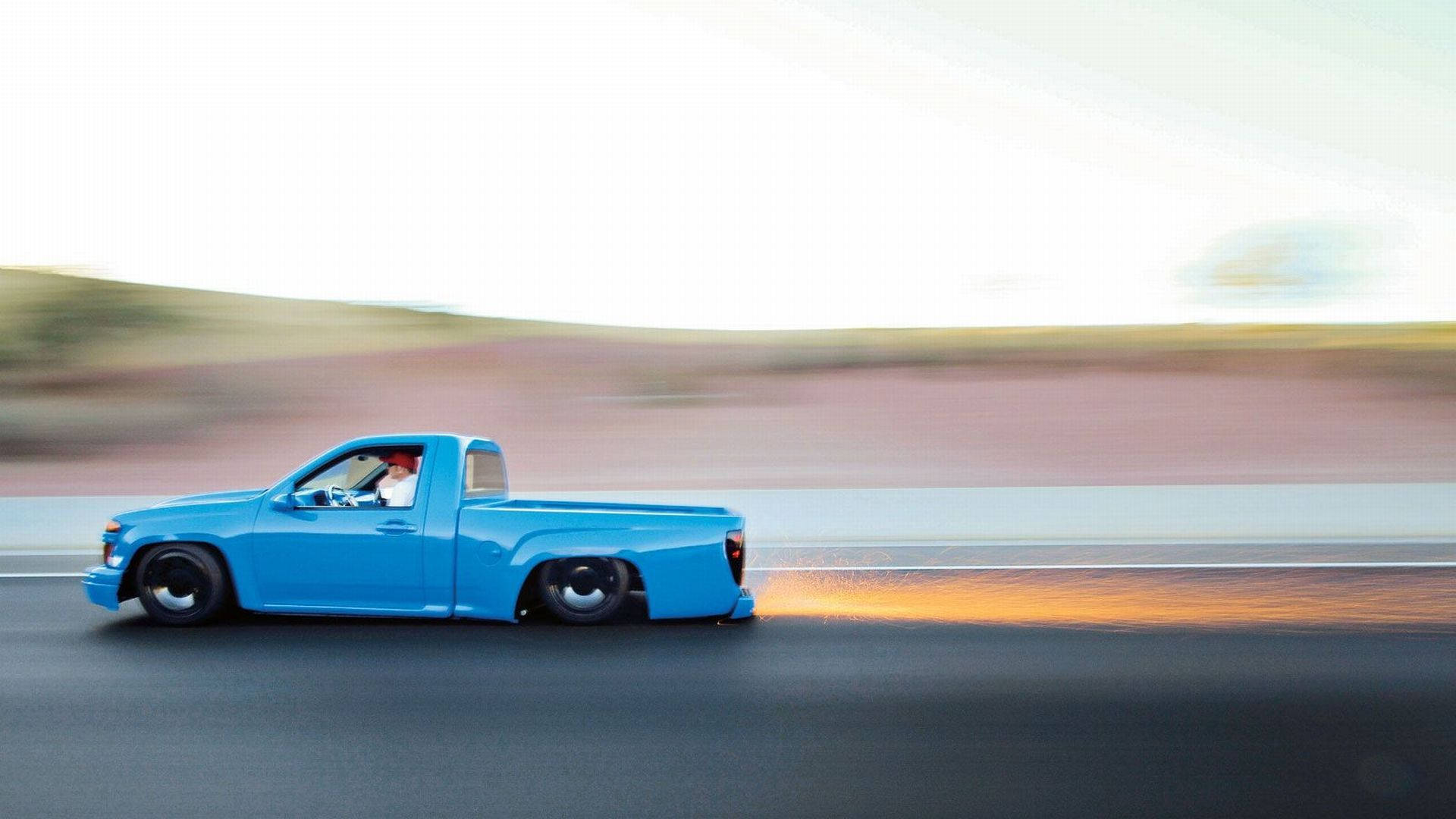 Download free Vibrant Blue Dropped Truck In Motion Wallpaper