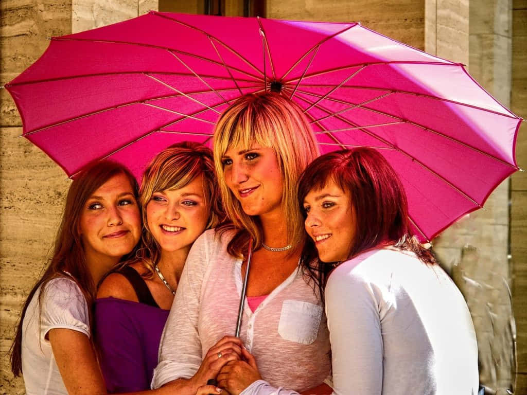 Vibrant Umbrella Four Women Smiling Wallpaper