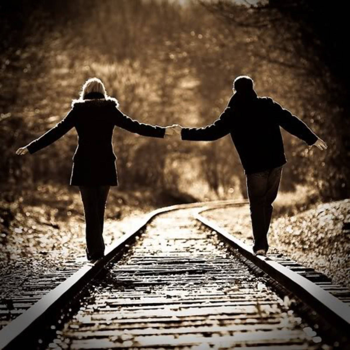 Walking Hand In Hand On A Railway Line Wallpaper