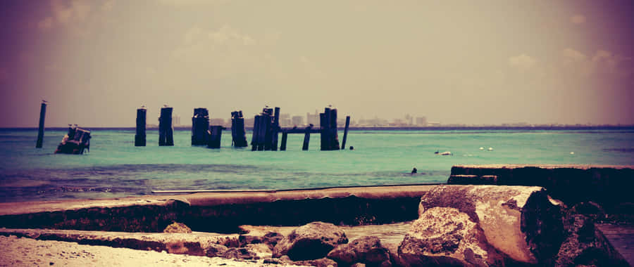 A Beach With A Boat In The Water Wallpaper
