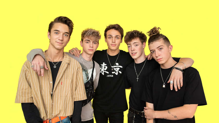 A Group Of Young Men Standing Together Wallpaper