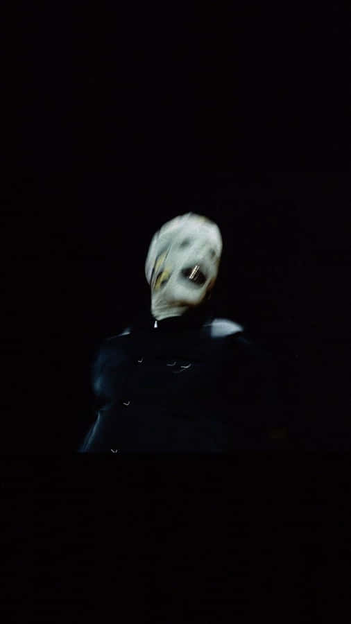 A Man In A Mask Is Standing In The Dark Wallpaper