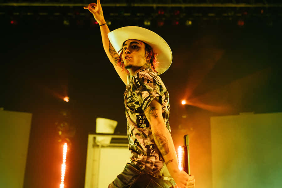 A Man In A White Hat On Stage Wallpaper