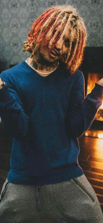 A Man With Dreadlocks Standing In Front Of A Fireplace Wallpaper