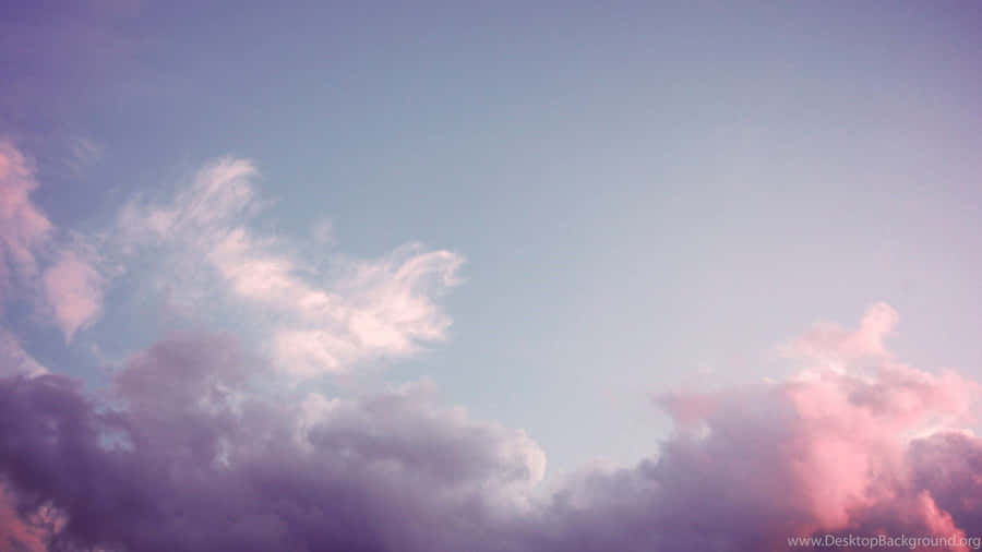 A Pink And Purple Sky With Clouds Wallpaper