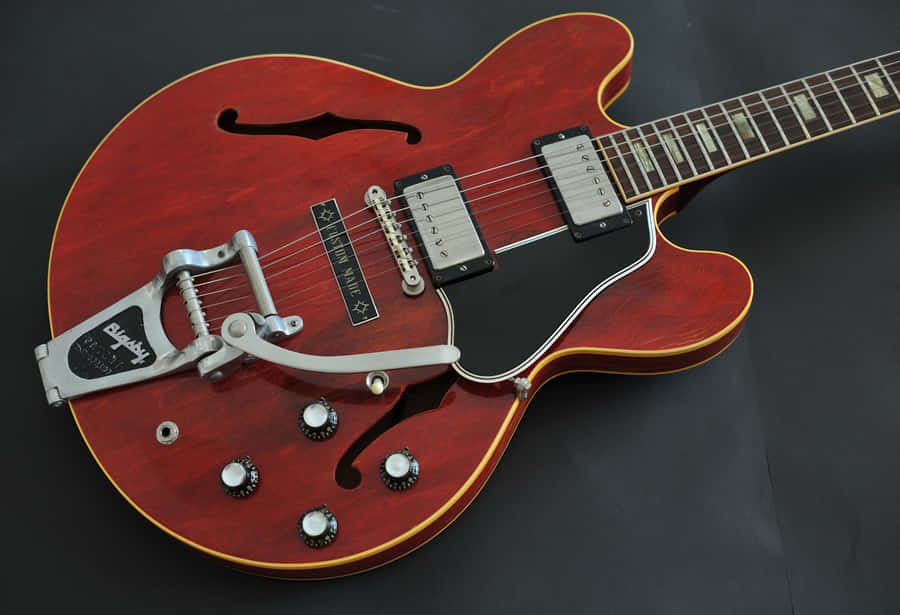 A Red Guitar With A Black Neck And A Black Body Wallpaper