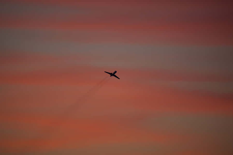 A Stunning Pink Plane Soaring Through The Sky Wallpaper