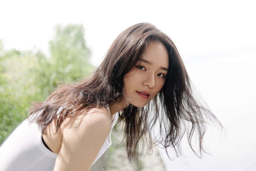 A Woman With Long Hair Posing By The Water Wallpaper