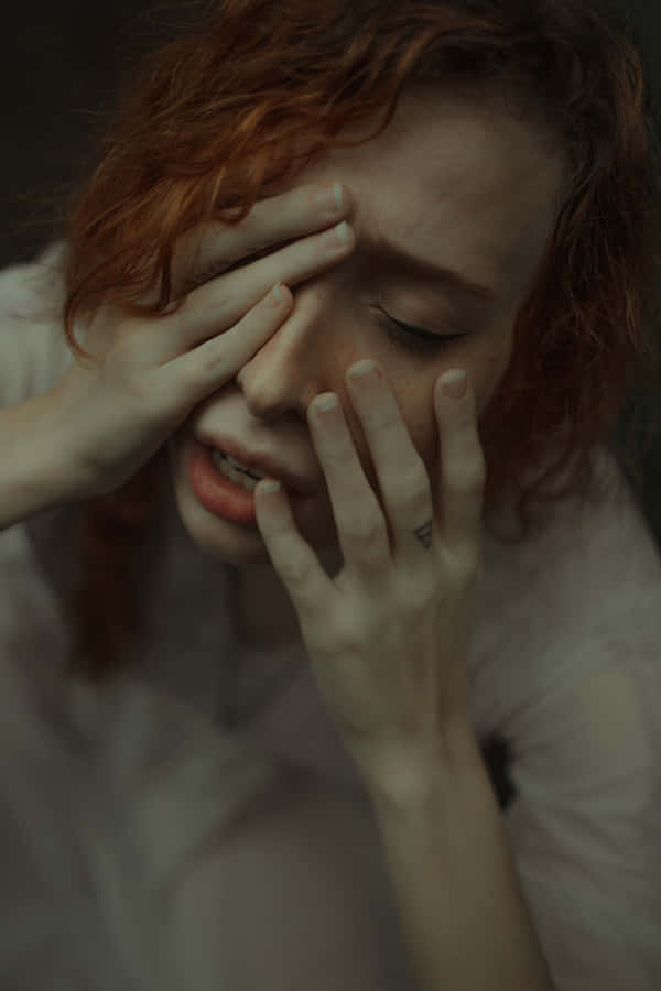 A Woman With Red Hair Covering Her Eyes Wallpaper