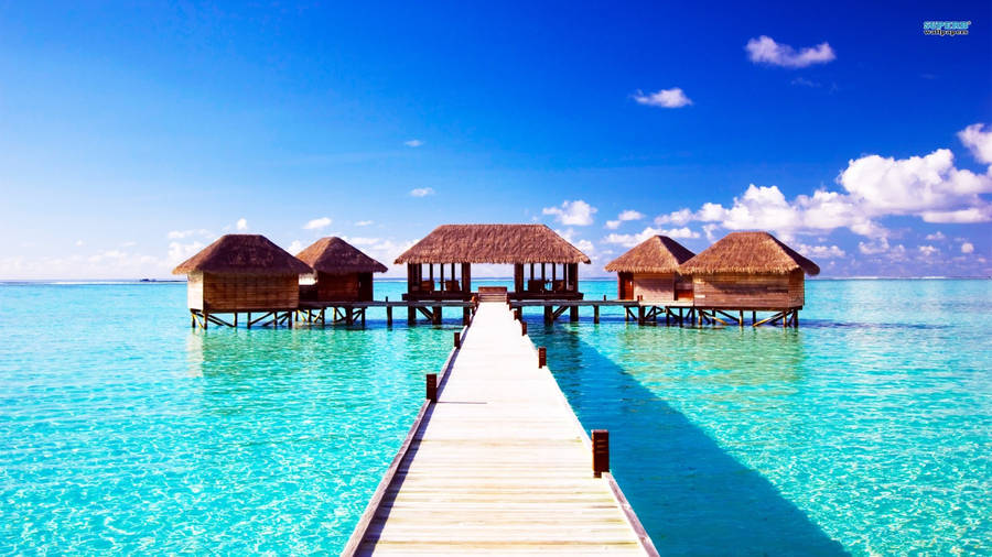 A Wooden Pier With Huts On It Wallpaper