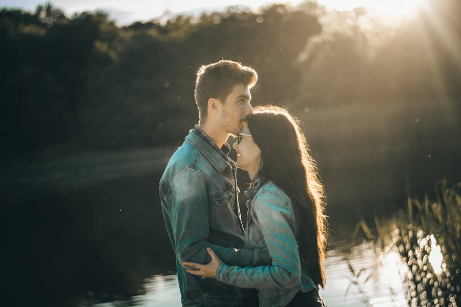 Couple Hugging With Kiss On Forehead Near River Wallpaper