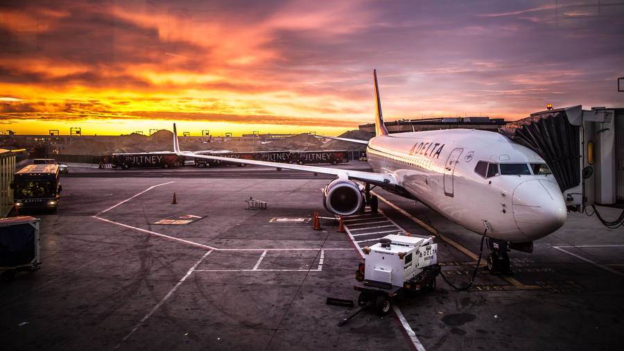 Download Delta Airlines Truck And Plane At Sunset Wallpaper | Wallpapers.com