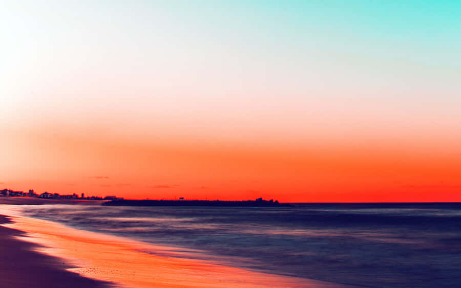 Enjoying A Beautiful Beach Day With A Laptop Wallpaper