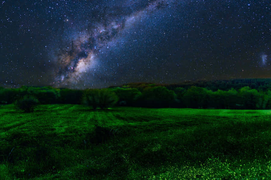 Explore The Depths Of The Universe With The Breathtaking Green And Blue Galaxy Wallpaper