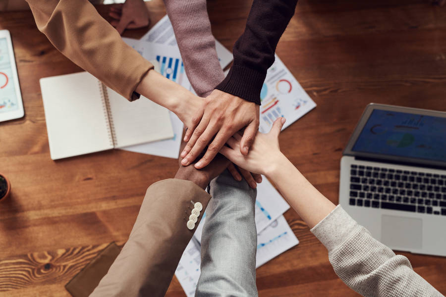 Group Of Employees Hands Together Wallpaper