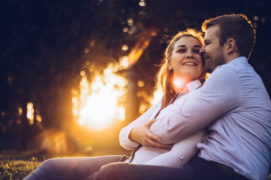 Happy Couple Hugging With Sunbeam Wallpaper