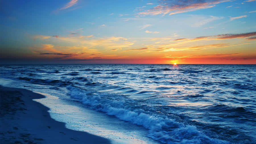 Pretty Ocean With Yellow-tinged Sky Wallpaper
