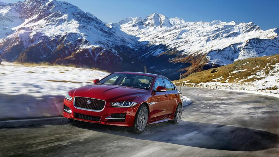 Red Jaguar Car Passing Mountains Wallpaper
