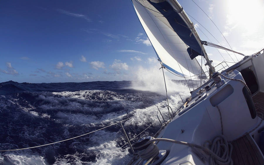 Sailing Yacht Braving Waves Wallpaper
