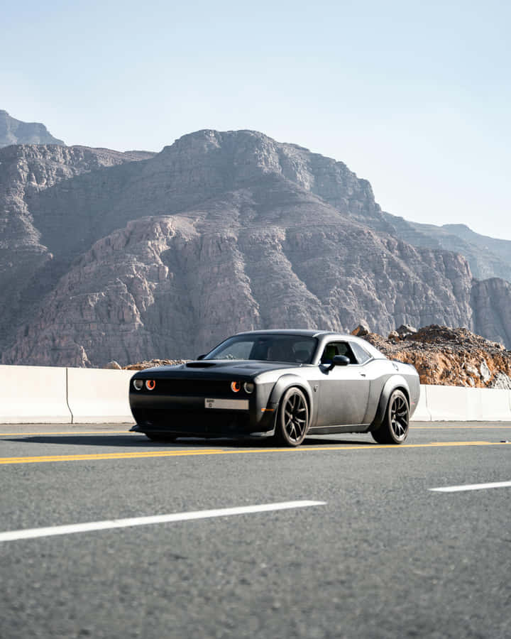 Sleek Black Car Mountain Road Wallpaper