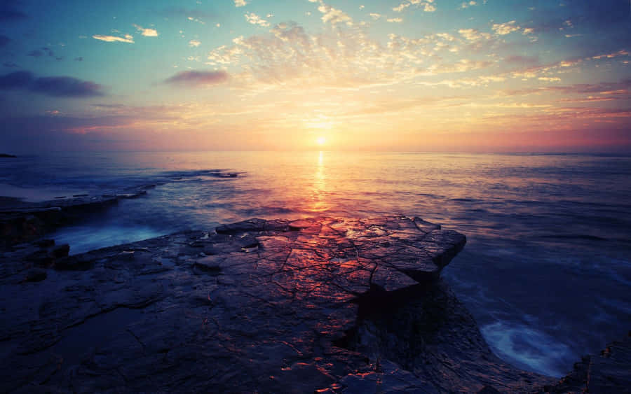 Taking In The Beauty Of A Peaceful Sunrise From Your Desktop Wallpaper