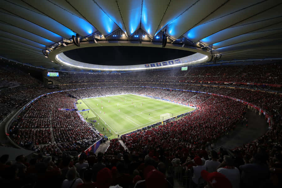 Thousands Of Fans Welcoming Their Home Team In A Vibrant Soccer Stadium Wallpaper