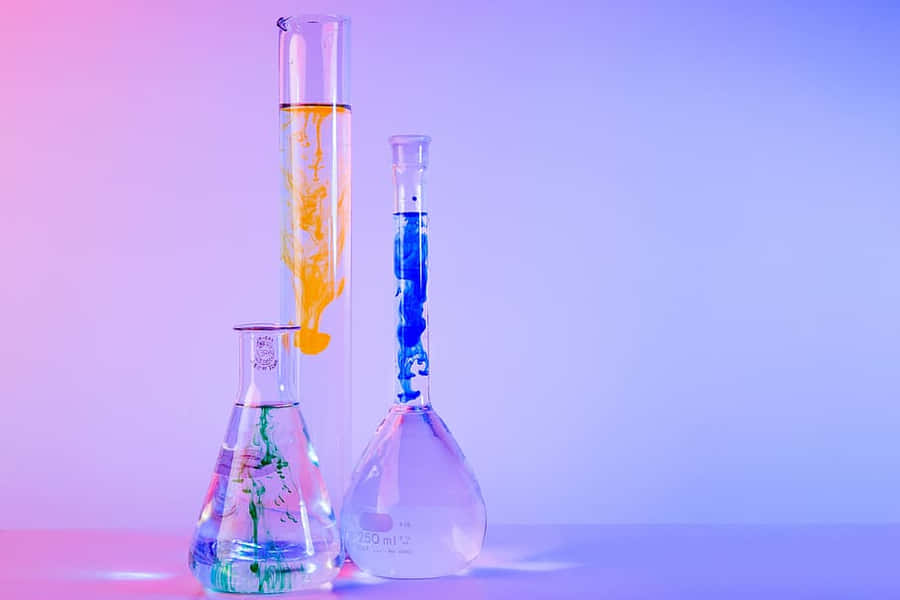 Three Glass Flasks With Different Colors Of Liquid Wallpaper