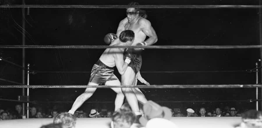 Tommy Loughran Delivering A Punch During A Boxing Match Wallpaper