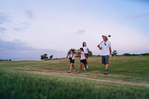4k Family Carrying Golf Clubs Wallpaper