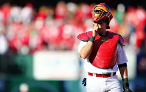 A Baseball Player Is Holding His Glove And Looking At The Ground Wallpaper