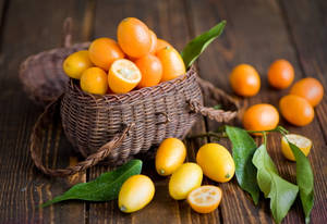 A Basket Of Bright And Fresh Kumquats Wallpaper