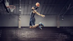 A Basketball Player In Mid Air Dunks A Ball Wallpaper