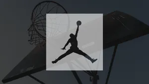 A Basketball Player Is Jumping Into A Hoop Wallpaper