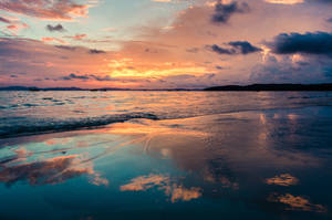 A Beach With A Sunset Wallpaper