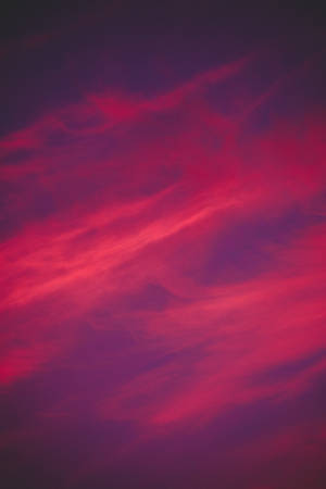 A Beautiful, Dark Pink Aesthetic Sunset Above The Clouds Wallpaper